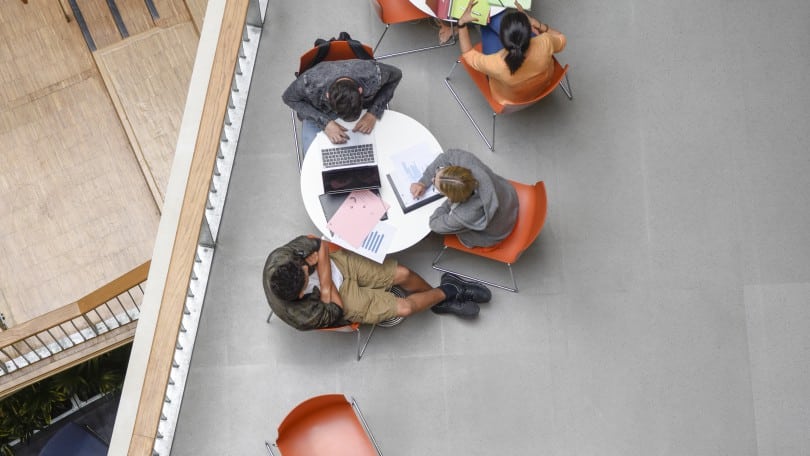 Overhead view of furniture on elevated platform with college students studying in groups